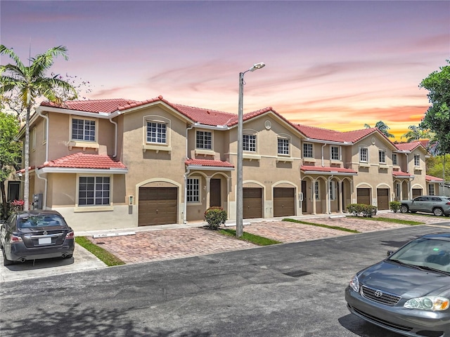 21115 NW 14th Pl Unit 2, Miami, FL 33169 - view of front of home featuring a garage, stucco siding, a tile roof, and driveway