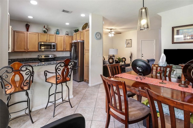 21115 NW 14th Pl Unit 2, Miami, FL 33169 - kitchen with appliances with stainless steel finishes, a peninsula, ceiling fan, light tile patterned floors, and a kitchen breakfast bar