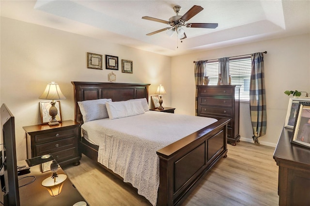 21115 NW 14th Pl Unit 2, Miami, FL 33169 - bedroom featuring a tray ceiling, light wood-type flooring, baseboards, and a ceiling fan