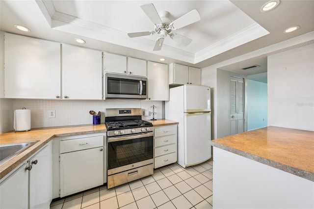 6020 S Shore Blvd Unit 709, Gulfport, FL 33707 - kitchen featuring stainless steel appliances, a tray ceiling, backsplash, white cabinetry, and recessed lighting