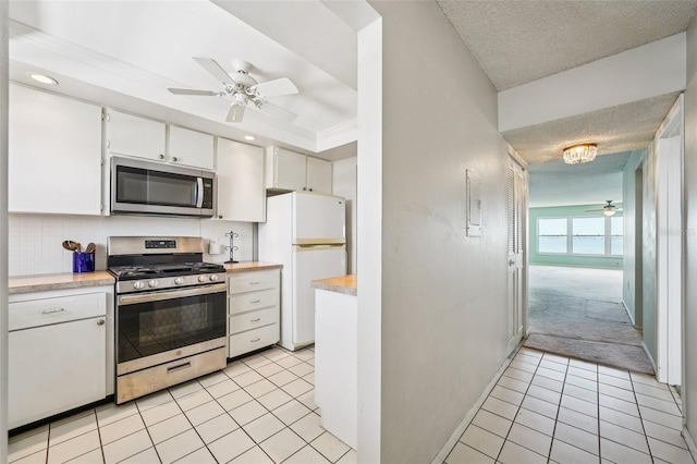 6020 S Shore Blvd Unit 709, Gulfport, FL 33707 - kitchen with stainless steel appliances, ceiling fan, light countertops, white cabinetry, and light tile patterned flooring
