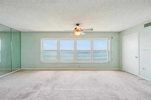 6020 S Shore Blvd Unit 709, Gulfport, FL 33707 - unfurnished room with a ceiling fan, carpet floors, a textured ceiling, and a water view