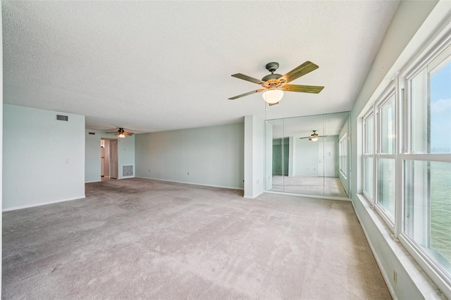 6020 S Shore Blvd Unit 709, Gulfport, FL 33707 - unfurnished room featuring a ceiling fan, healthy amount of natural light, light carpet, and a textured ceiling