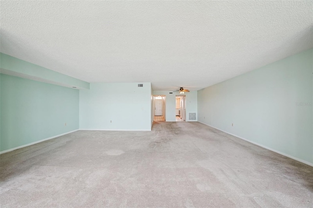 6020 S Shore Blvd Unit 709, Gulfport, FL 33707 - unfurnished living room featuring a textured ceiling, light carpet, and a ceiling fan