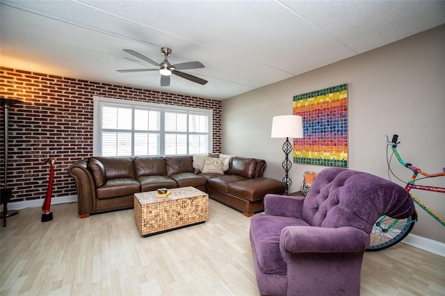 12300 Park Blvd Unit 222, Seminole, FL 33772 - living room with brick wall, ceiling fan, wood finished floors, and baseboards