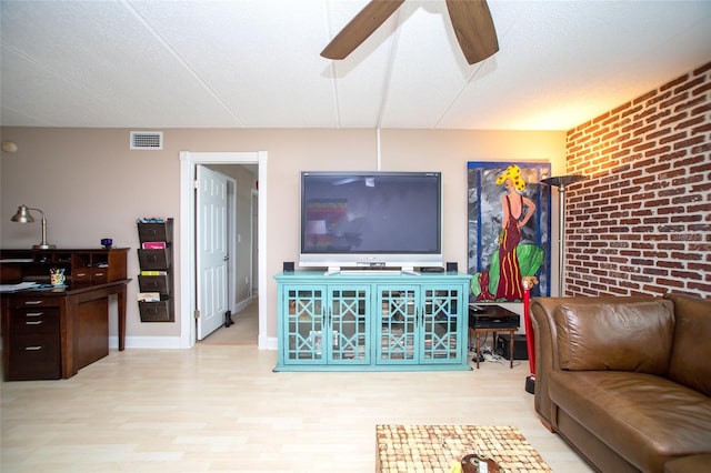 12300 Park Blvd Unit 222, Seminole, FL 33772 - living area featuring a ceiling fan, light wood-type flooring, and brick wall
