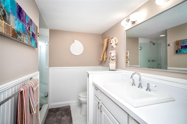 12300 Park Blvd Unit 222, Seminole, FL 33772 - full bathroom featuring a shower with door, a wainscoted wall, toilet, tile patterned floors, and vanity