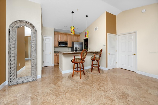 10764 70th Ave Unit 5302, Seminole, FL 33772 - kitchen featuring stainless steel appliances, a kitchen bar, high vaulted ceiling, a peninsula, and pendant lighting