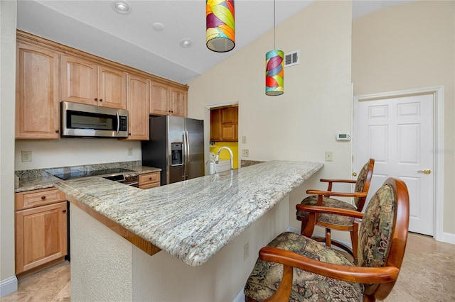 10764 70th Ave Unit 5302, Seminole, FL 33772 - kitchen with appliances with stainless steel finishes, a peninsula, a breakfast bar, light stone countertops, and baseboards