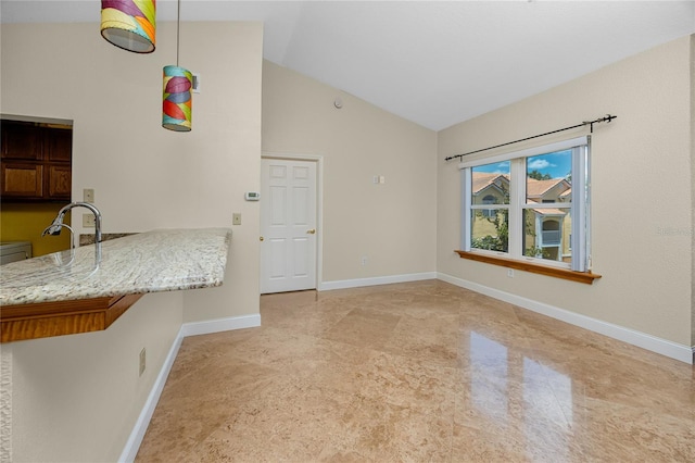 10764 70th Ave Unit 5302, Seminole, FL 33772 - kitchen with baseboards, high vaulted ceiling, light stone counters, and a peninsula