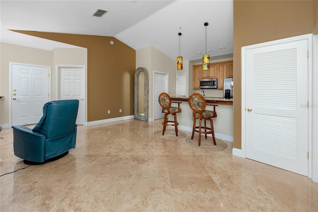 10764 70th Ave Unit 5302, Seminole, FL 33772 - kitchen featuring stainless steel appliances, a breakfast bar area, vaulted ceiling, decorative light fixtures, and baseboards