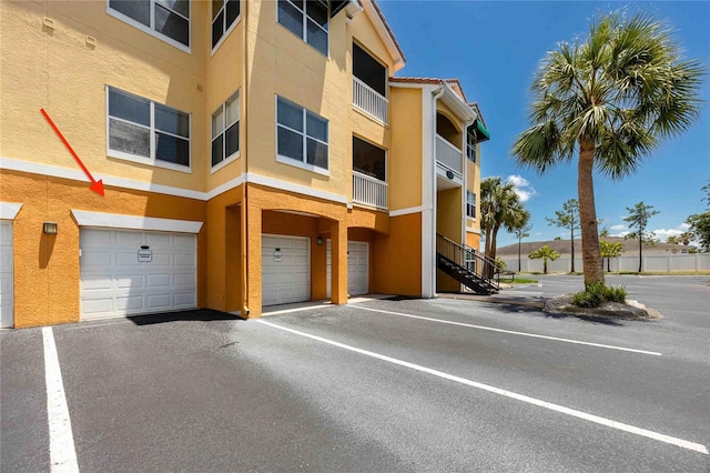 10764 70th Ave Unit 5302, Seminole, FL 33772 - view of apartment building / complex with a garage, driveway, and stairway