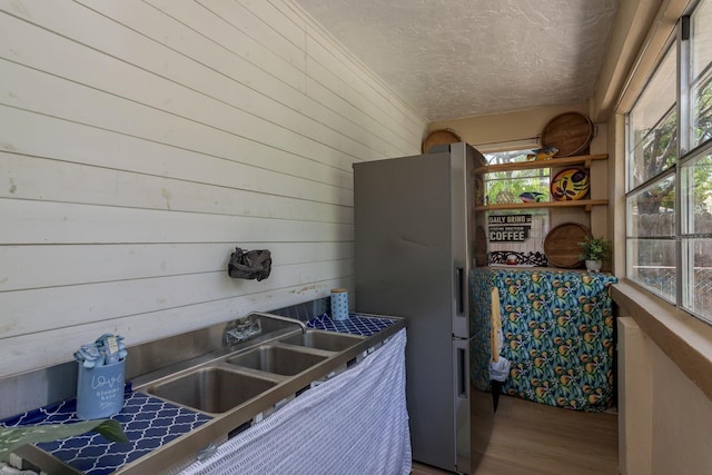 314 Bath St, Tarpon Springs, FL 34689 - kitchen with freestanding refrigerator, a textured ceiling, wooden walls, and wood finished floors