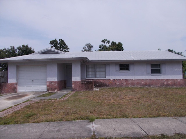 ranch-style house with an attached garage, brick siding, stucco siding, a front yard, and concrete driveway