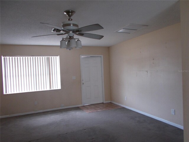 carpeted empty room with a ceiling fan and baseboards