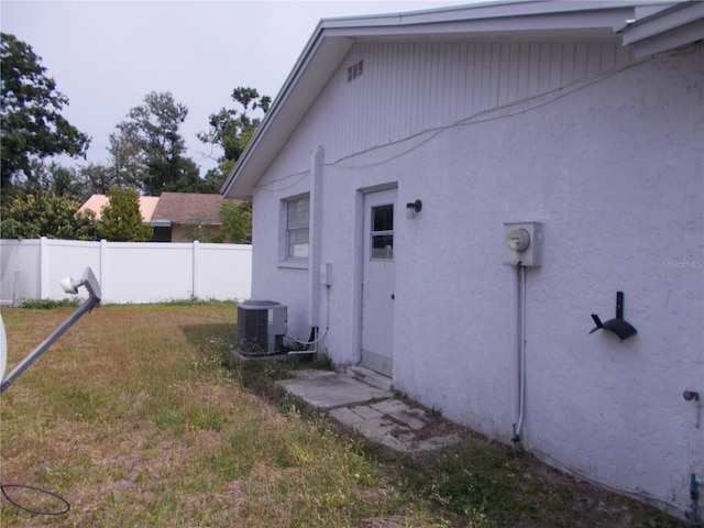 view of property exterior with central air condition unit and stucco siding