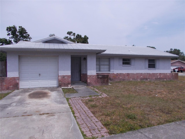 ranch-style house featuring stucco siding, an attached garage, and brick siding