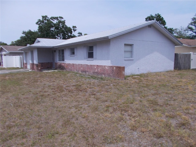 ranch-style home with brick siding, stucco siding, metal roof, and a garage