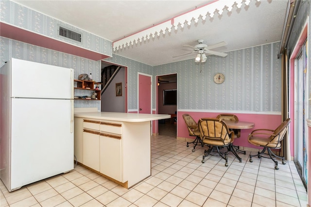 7317 W Pocahontas Ave, Tampa, FL 33634 - kitchen with freestanding refrigerator, a peninsula, a ceiling fan, light countertops, and light tile patterned flooring