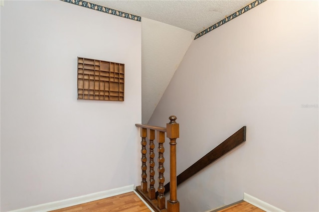 7317 W Pocahontas Ave, Tampa, FL 33634 - staircase featuring wood finished floors, a textured ceiling, and baseboards