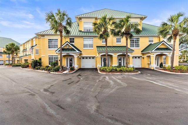 6319 Sunset Bay Cir, Apollo Beach, FL 33572 - townhome / multi-family property with a standing seam roof, metal roof, driveway, and stucco siding
