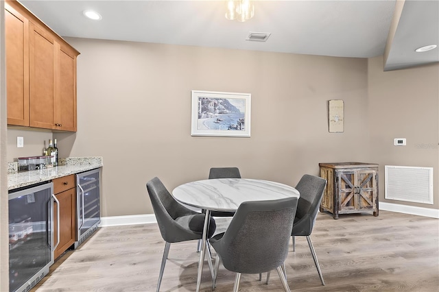 6319 Sunset Bay Cir, Apollo Beach, FL 33572 - dining room with wine cooler, a dry bar, baseboards, light wood-style floors, and recessed lighting