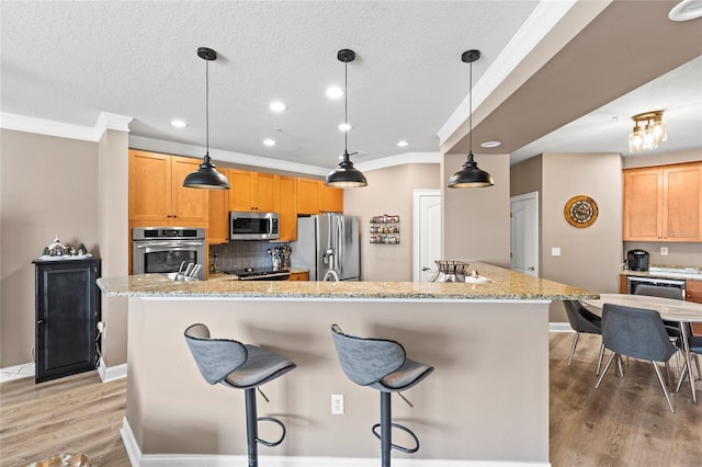 6319 Sunset Bay Cir, Apollo Beach, FL 33572 - kitchen featuring appliances with stainless steel finishes, crown molding, light wood-style flooring, backsplash, and a textured ceiling