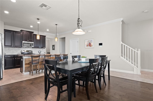 4264 Bexley Village Dr, Land O Lakes, FL 34638 - dining space featuring dark wood finished floors, ornamental molding, stairway, recessed lighting, and baseboards