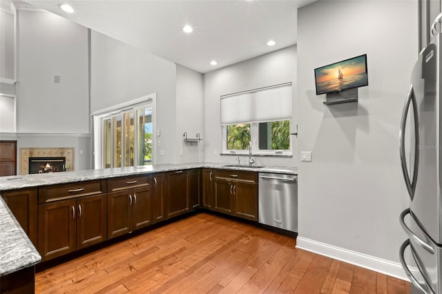 1171 Red Maple Cir NE, Saint Petersburg, FL 33703 - kitchen with stainless steel appliances, light stone counters, light wood-style flooring, a sink, and recessed lighting