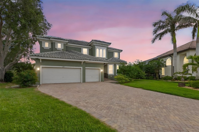1171 Red Maple Cir NE, Saint Petersburg, FL 33703 - view of front of property with decorative driveway, an attached garage, stucco siding, and a lawn