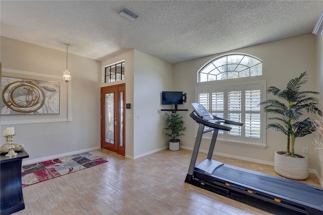 3338 Laurelwood Ct, Tarpon Springs, FL 34688 - exercise area featuring wood finished floors, a textured ceiling, and baseboards