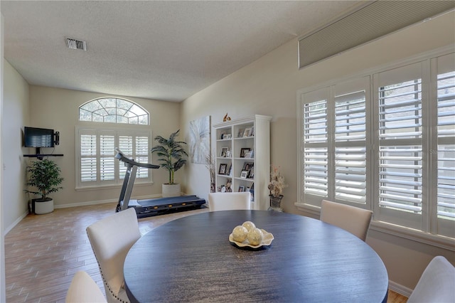 3338 Laurelwood Ct, Tarpon Springs, FL 34688 - dining space featuring wood finished floors, baseboards, and a textured ceiling