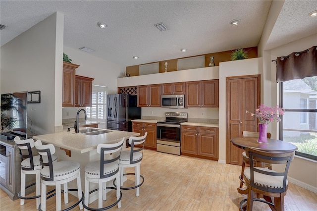 3338 Laurelwood Ct, Tarpon Springs, FL 34688 - kitchen featuring stainless steel appliances, a sink, a peninsula, light countertops, and light wood-style flooring