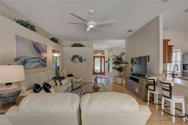 3338 Laurelwood Ct, Tarpon Springs, FL 34688 - living room with a ceiling fan, light wood-style flooring, and a textured ceiling