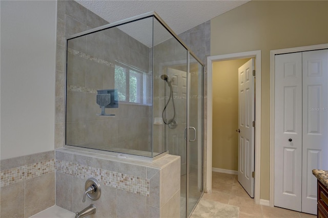 3338 Laurelwood Ct, Tarpon Springs, FL 34688 - bathroom featuring a shower stall, tile patterned flooring, a closet, a garden tub, and a textured ceiling