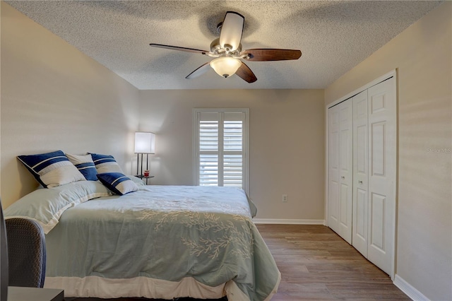 3338 Laurelwood Ct, Tarpon Springs, FL 34688 - bedroom featuring a textured ceiling, baseboards, wood finished floors, a closet, and a ceiling fan