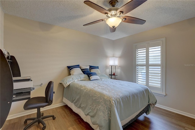 3338 Laurelwood Ct, Tarpon Springs, FL 34688 - bedroom featuring baseboards, a textured ceiling, wood finished floors, and a ceiling fan