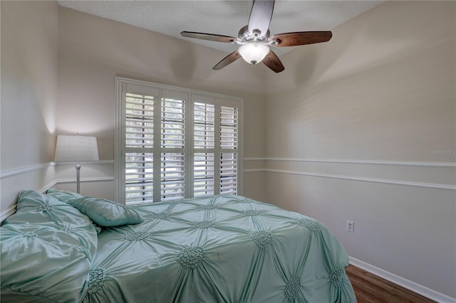 3338 Laurelwood Ct, Tarpon Springs, FL 34688 - bedroom with wood finished floors, multiple windows, a ceiling fan, baseboards, and a textured ceiling
