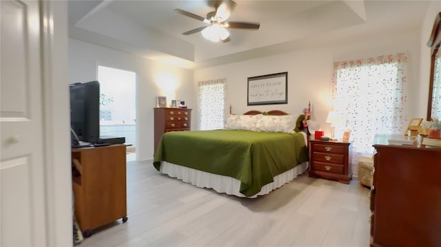 14116 Whitecap Ave, Hudson, FL 34667 - bedroom with multiple windows, a raised ceiling, light wood-type flooring, and a ceiling fan