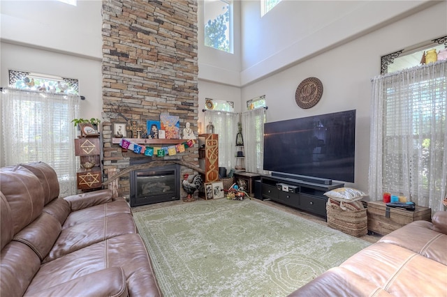 living area with a high ceiling, plenty of natural light, and a fireplace