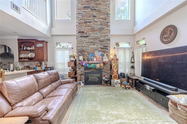 living area featuring a high ceiling and a stone fireplace
