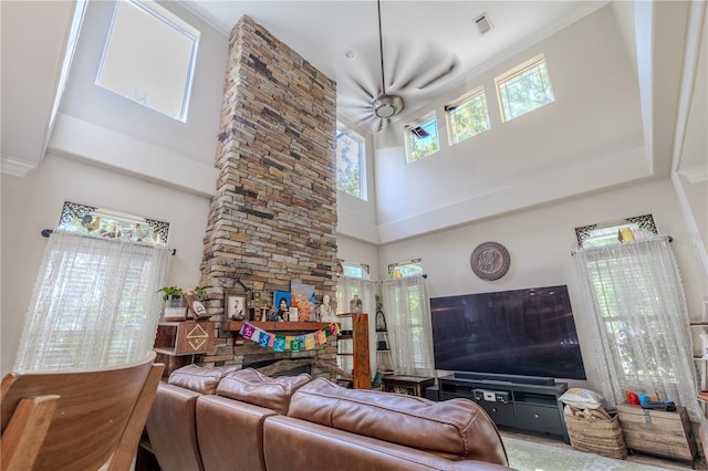 living room featuring a towering ceiling, a fireplace, and a ceiling fan