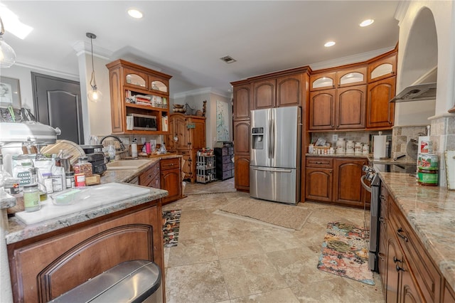 kitchen with stainless steel appliances, a sink, ornamental molding, ventilation hood, and brown cabinetry