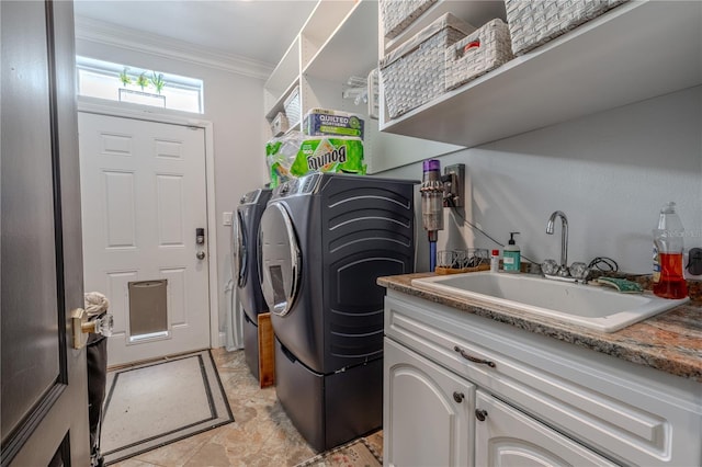clothes washing area with washing machine and clothes dryer, ornamental molding, and a sink