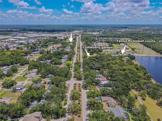 drone / aerial view of a large body of water and a tree filled landscape