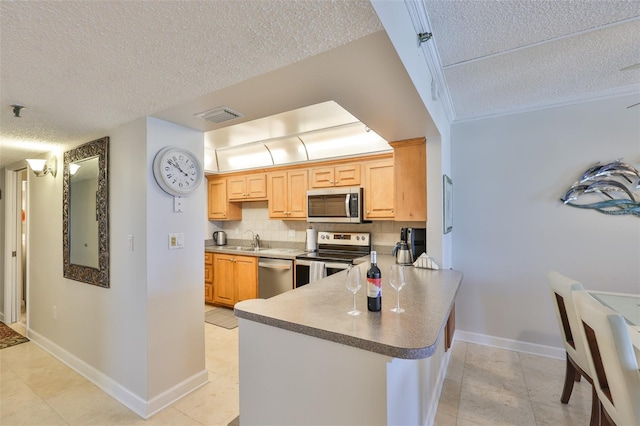 13720 Gulf Blvd Unit 302, Madeira Beach, FL 33708 - kitchen with appliances with stainless steel finishes, a textured ceiling, a sink, a peninsula, and backsplash