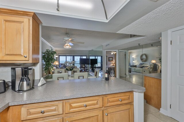 13720 Gulf Blvd Unit 302, Madeira Beach, FL 33708 - kitchen with a ceiling fan, open floor plan, a peninsula, light countertops, and a textured ceiling