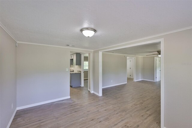 2112 33rd St SE, Ruskin, FL 33570 - empty room with crown molding, wood finished floors, a textured ceiling, baseboards, and ceiling fan