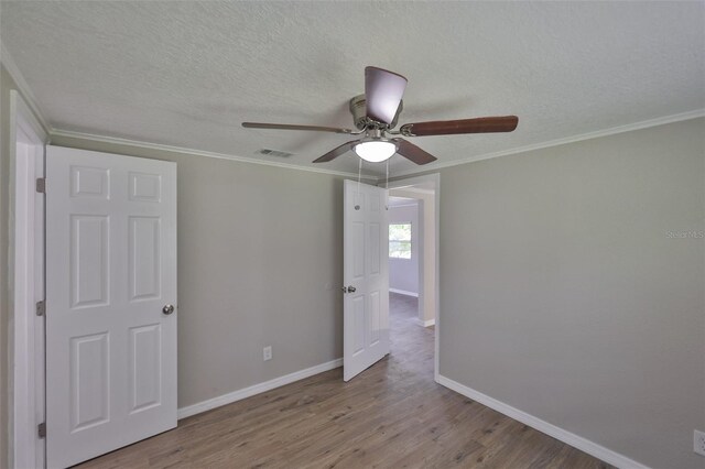 2112 33rd St SE, Ruskin, FL 33570 - empty room with baseboards, a ceiling fan, wood finished floors, a textured ceiling, and crown molding