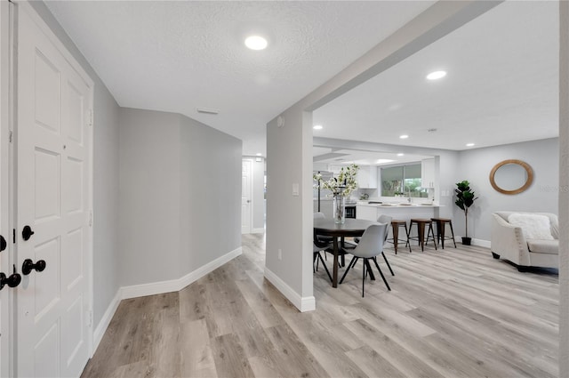 6914 Harbor Dr, Hudson, FL 34667 - dining room featuring baseboards, light wood-style floors, recessed lighting, and a textured ceiling